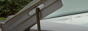 A hot tub cover raised on a cover lift.