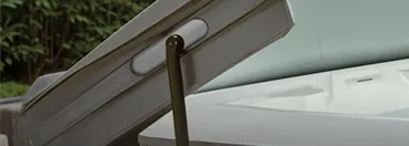 A hot tub cover raised on a cover lift.